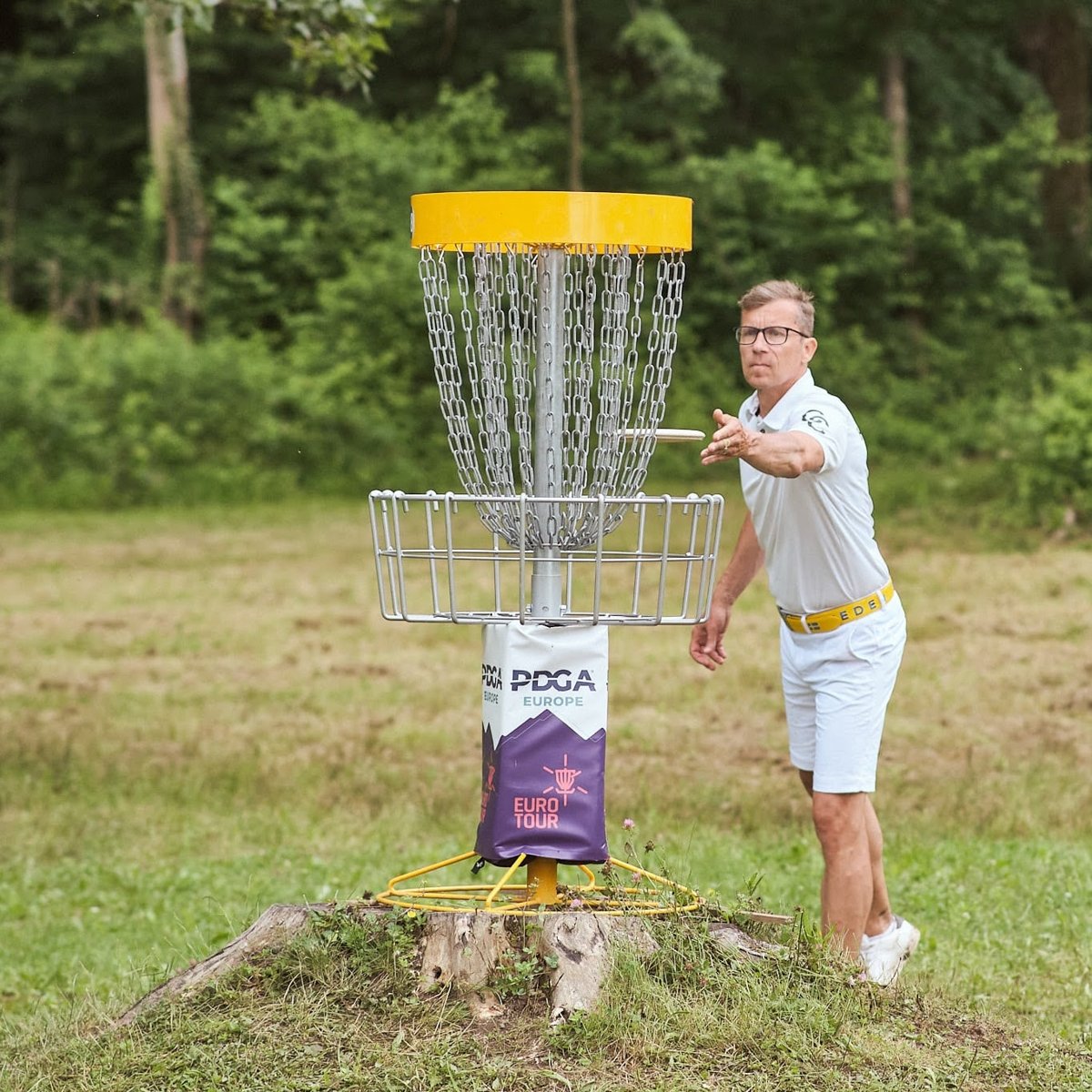 Discgolfspelare puttar mot en discgolfkorg